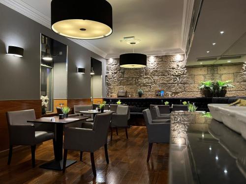 格拉斯哥Best Western Glasgow Hotel的一间带桌椅和石墙的餐厅