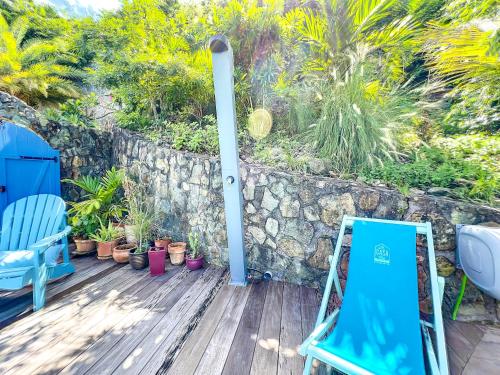 KoolbaaiMoonstone, private room in Villa Casa Blue pool sea view的一个带蓝色椅子和石墙的甲板