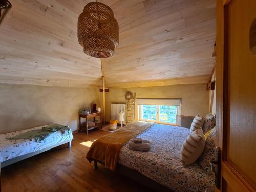 Saint-Sylvestre-sur-LotLe Coq en Repos的一间卧室设有一张床和木制天花板