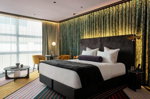 惠灵顿Naumi Hotel Wellington的酒店客房设有一张大床和一张桌子。