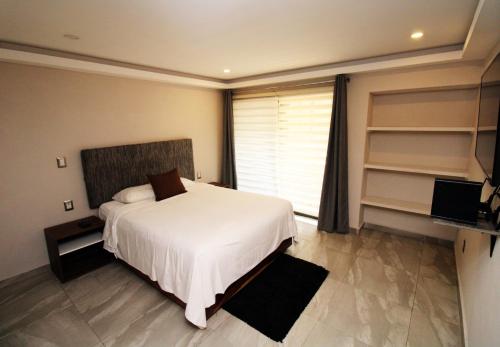 墨西哥城OSLO 5的卧室设有白色的床和大窗户