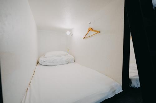 东京Le Glaciel 5 4F - Vacation STAY 79673v的白色的房间,设有一张床和墙上的衣架