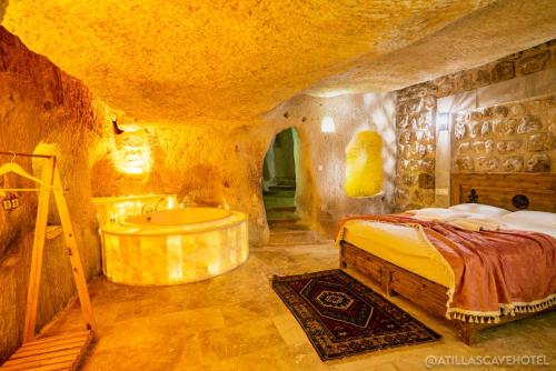 内夫谢希尔Atilla's Cave Hotel的一间卧室配有一张床和浴缸
