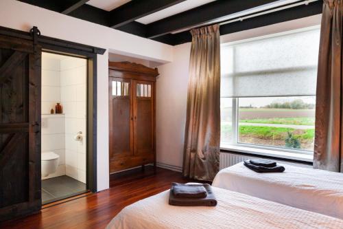 OverschildPait's Laand Bed & Breakfast的一间卧室设有两张床和大窗户