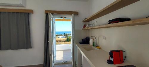 基莫洛斯岛Casa Di Kimolos的厨房配有水槽和带窗户的台面