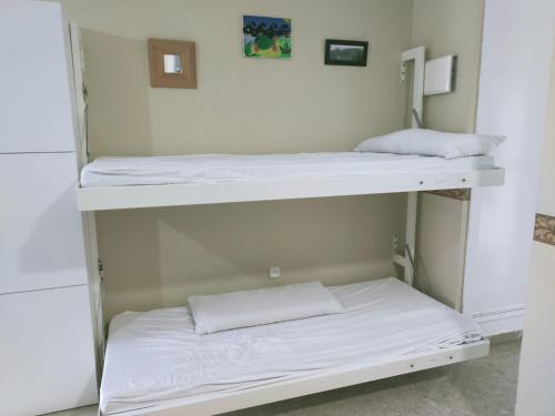 罗塔SOLEA 17的配有白色床单的客房内的两张双层床