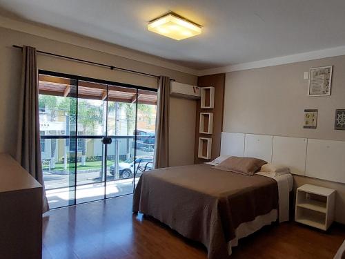 弗洛里亚诺波利斯Pousada Casa Da Praia的一间卧室设有一张床和一个滑动玻璃门