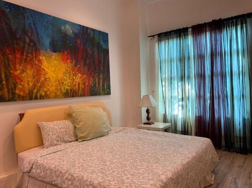古晋古晋韦斯博里公寓的卧室配有一张床,墙上挂着一幅大画