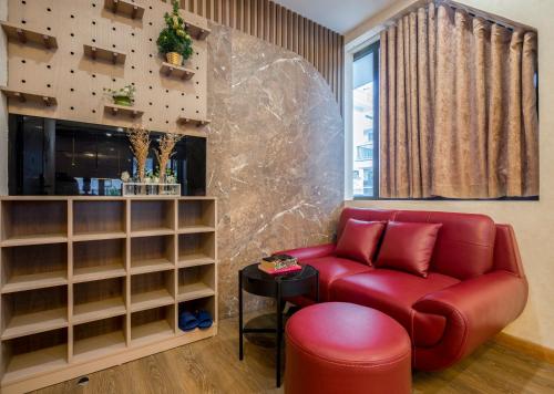 下龙湾BBQ HOSTEL的客厅配有红色的沙发和桌子