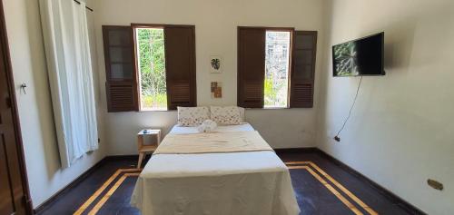 马瑙斯Casa 307的一间设有床铺的卧室,位于带窗户的房间内