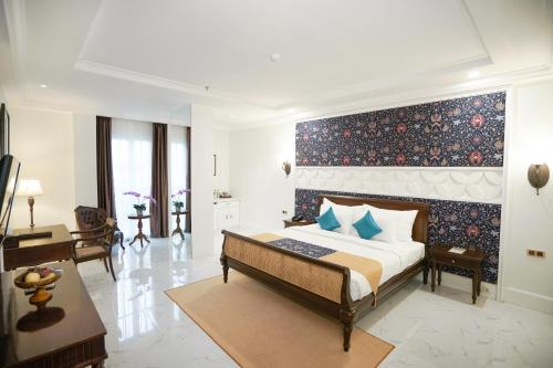 梭罗MAHALAYA The Legacy Hotel的一间卧室设有一张蓝色墙壁的大床