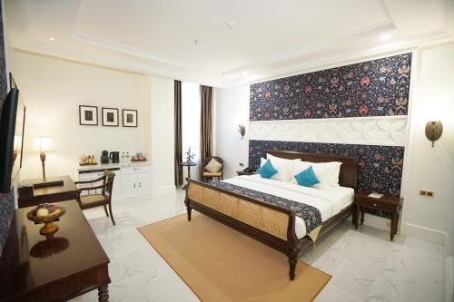 梭罗MAHALAYA The Legacy Hotel的一间卧室配有一张特大号床和一张书桌
