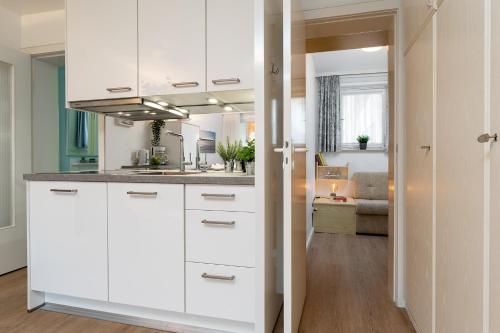 格洛米茨Strandschloss Wolke 7的一间带白色橱柜的厨房和一间客厅