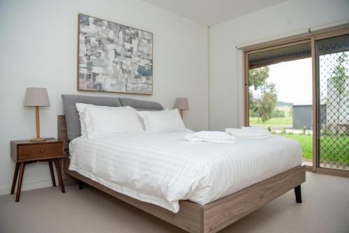 赛特菲尔德Triple Creek Guest House - Barossa Region的卧室配有一张大白色床和窗户