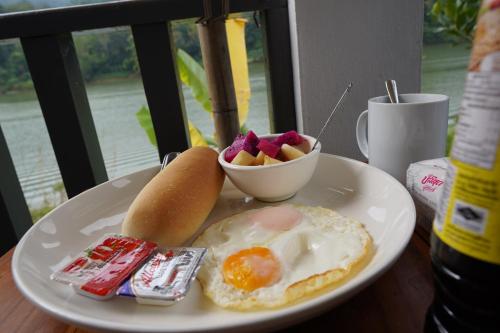 NongkhiawNam ou view villa的鸡蛋和一碗水果的盘子