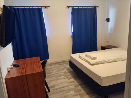 伊策霍City Centre Unterkunft的小房间,配有床和蓝色窗帘