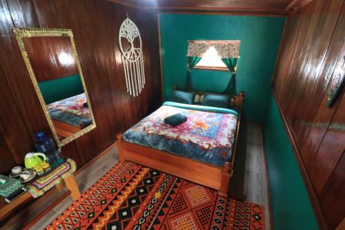 Kayu AroPelangi Guest House的一间小卧室,配有一张床和镜子