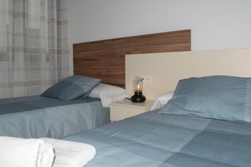 阿尔卡拉拉雷亚尔Deluxe Apartament Alcalá la Real的一间卧室配有两张床和床头灯。