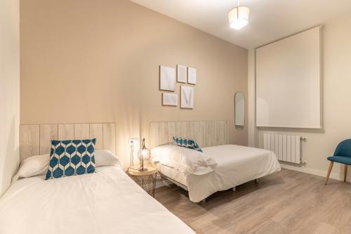毕尔巴鄂Recién reformado junto a metro San Mamés的一间卧室配有两张床和一张蓝色椅子