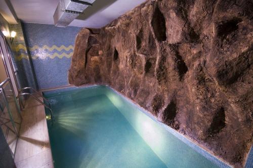 伊斯坦布尔格兰德艾玉波格鲁酒店的石头墙前的游泳池