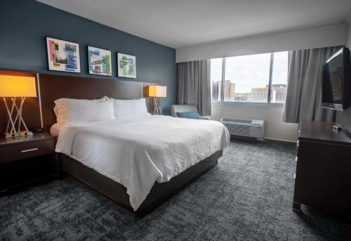 苏福尔斯苏福尔斯市中心假日酒店的酒店客房设有一张床和一个大窗户