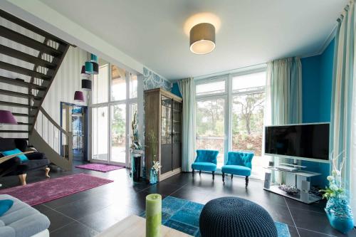 卡尔斯哈根Kapitaensweg 24的客厅设有蓝色的墙壁和电视。