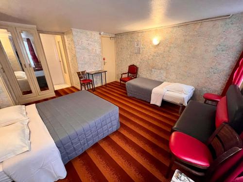 巴黎Hôtel Tiquetonne的酒店客房带两张床和一张桌子以及椅子。