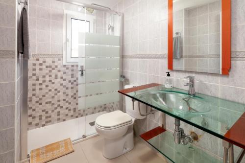 奇尔切斯Villa Pepa的一间带卫生间和玻璃水槽的浴室