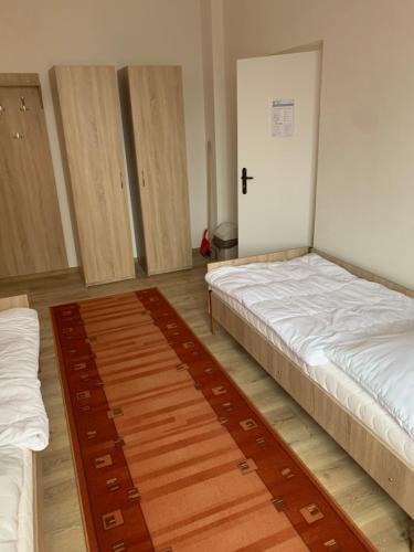 Moldava nad BodvouHostel SOS Moldava的一间设有两张床的房间,其中有一扇门