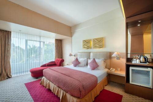 玛琅Lux Tychi Hotel的酒店客房,配有床和电视