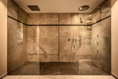塞尔瓦迪加尔代纳山谷Luxury Chalet Plazola的带淋浴的浴室和玻璃门