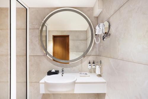 艾哈迈达巴德Keys Select by Lemon Tree Hotels, Gandhi Ashram, Ahmedabad的浴室设有白色水槽和镜子