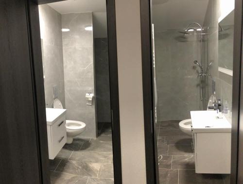滨湖采尔Landhaus Marlies Apartments的浴室配有2个盥洗盆、卫生间和淋浴。