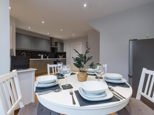 泰恩河畔纽卡斯尔Charming 3-Bed House in Newcastle upon Tyne的厨房以及带白色桌椅的用餐室。