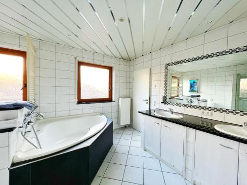 腓特烈港Hotel Hellers Twenty Four II -24h-Check-In-的白色的浴室设有浴缸和两个盥洗盆