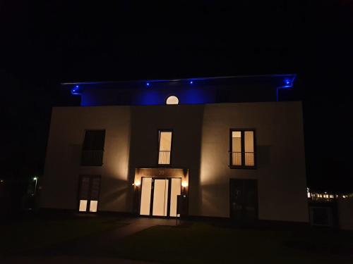 格赫伦-莱宾Luxus Spa Penthouse Sundowner的夜晚亮着蓝色灯的房子