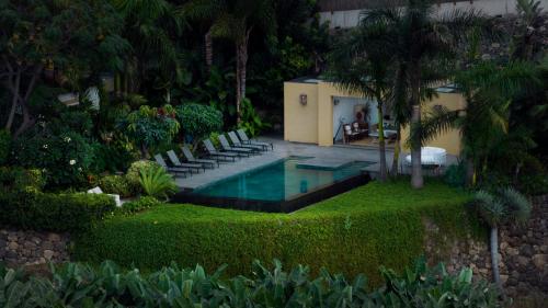 洛斯雷亚莱霍斯Hacienda Cuatro Ventanas的一个带椅子的庭院和房子的游泳池