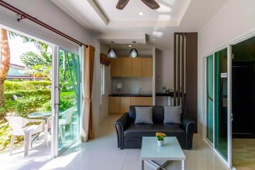 高兰Phutara Lanta Resort - SHA Extra Plus Koh Lanta的客厅配有沙发和桌子