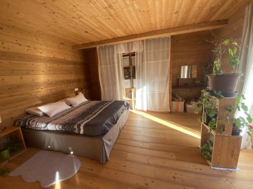 EntraunesChalet Miel de la Cayolle-Estenc的木制客房内的一间卧室,配有一张床