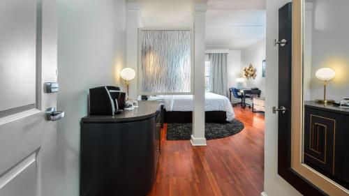 杰克逊维尔杰克逊迪尔伍德公园靛蓝酒店的一间卧室配有一张床和一张带镜子的书桌