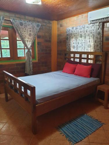 格罗斯岛Seawind Cottage Authentic St.Lucian Accommodation near Plantation Beach的一张带两个红色枕头的床