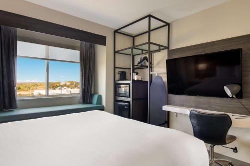 克拉里恩MainStay Suites Clarion, PA near I-80的酒店客房配有一张床、一张书桌和一台电视。