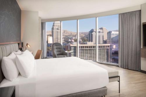 盐湖城Hyatt Regency Salt Lake City的卧室设有一张白色大床和大窗户