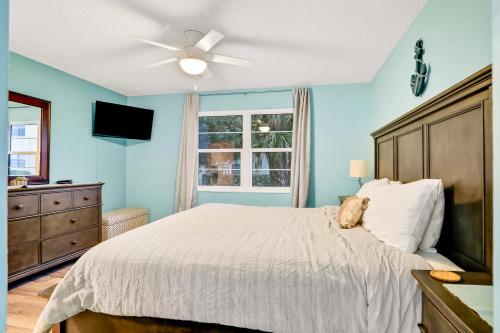圣奥古斯丁Clipper Cabana Beachwalk Condo的一间卧室配有一张带吊扇和窗户的床。