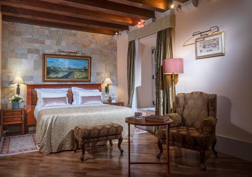 杜布罗夫尼克普谢克宫殿酒店的卧室配有一张床和一张桌子及椅子