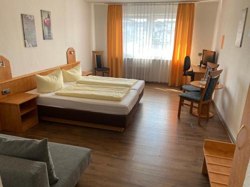 伊德施泰因Hotel Sonne - Haus 1的一间卧室配有一张床、一把椅子和一张沙发