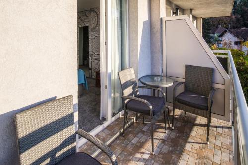 萨拉热窝Hotel Villa Harmony的阳台的天井配有桌椅
