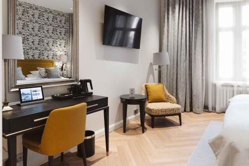 赫尔辛基Hotel Bastian的酒店客房设有一张桌子、一张床和一间卧室。
