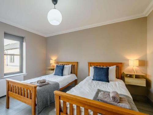 巴洛赫Westertonhill Lodge 3 with Hot Tub Option的一间卧室设有两张床和窗户。
