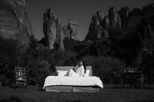 卡兰巴卡皮尔格斯阿达奇迪酒店的坐在田野上床边的女人
